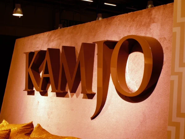 Kamjo mahulised pruunid MDF-tähed värvilisel seinal interjööris