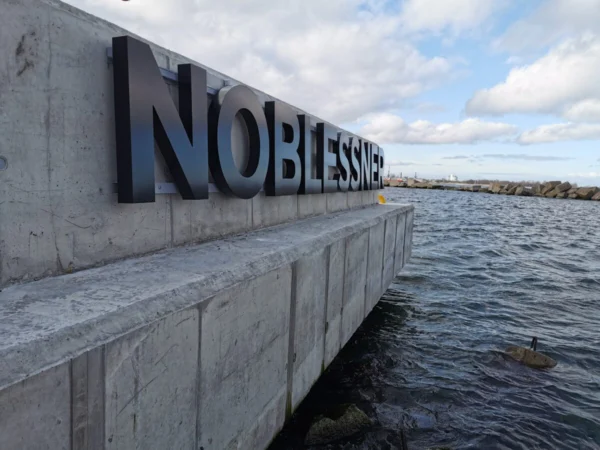 Noblessneri mustad mahulised tähed betoonist kaimüüril mere ääres