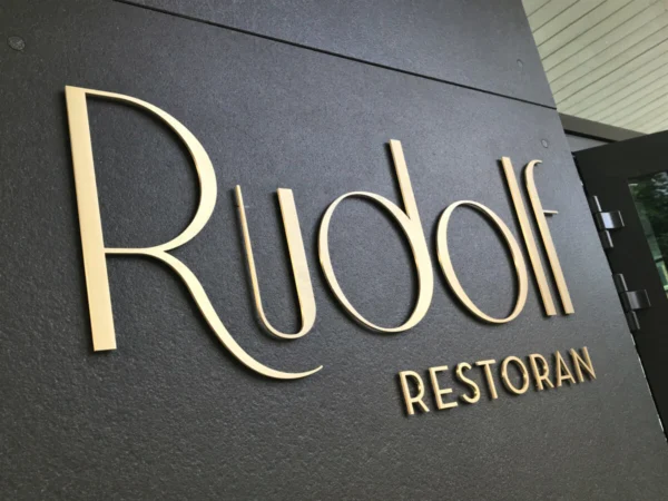 Rudolfi restorani kuldsed mahulised tähed tumedal teksturiiritud fassaadil