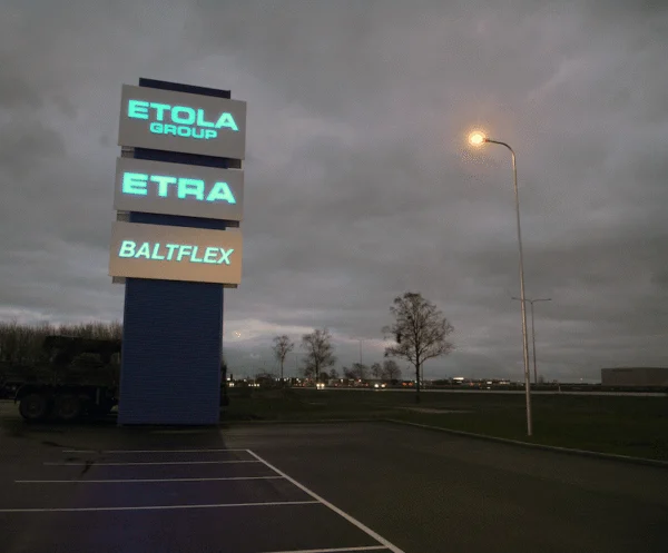 Kolme brändiga pülon büroopargi parkla ääres hämaral õhtul