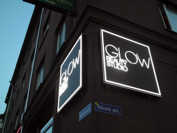 GLOW Beauty Studio kaks perpendikulaarset valguskasti hoonenurgal õhtuhämaruses