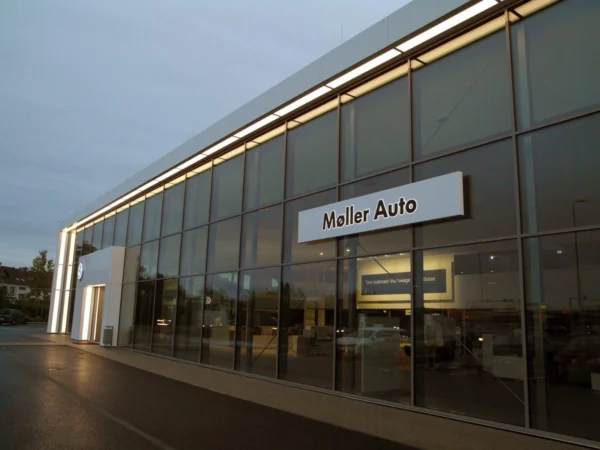 Møller Auto valguskast klaasfassaadiga autoesinduse küljel õhtuhämaruses