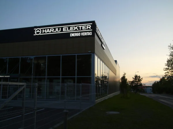 Harju Elekter Energo Veritas valgustatud logo tootmishoone katuseserval õhtuhämaruses