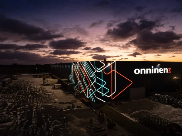 Onnineni valgustatud logo laohoone fassaadil koos värvilise LED-neoon dekoratiivse kujundusega