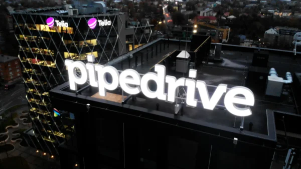 Pipedrive'i suured valgustatud tähed ärihoone katusel õhtul, taustal Telia logod