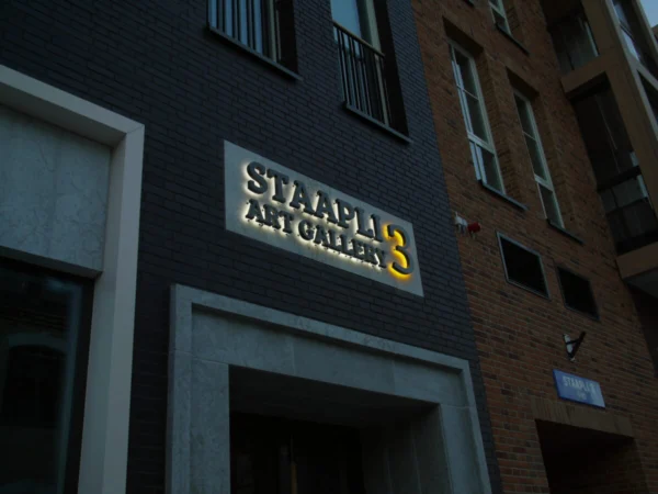 Staapli 3 Art Gallery taustvalgustatud tähed sissepääsu kohal telliskivifassaadil