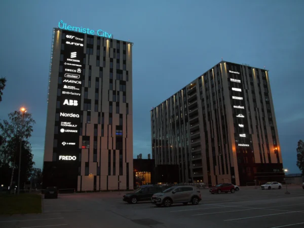 Ülemiste City tornide valgustatud logod ja brändinimed mitme rentniku fassaadidel õhtul